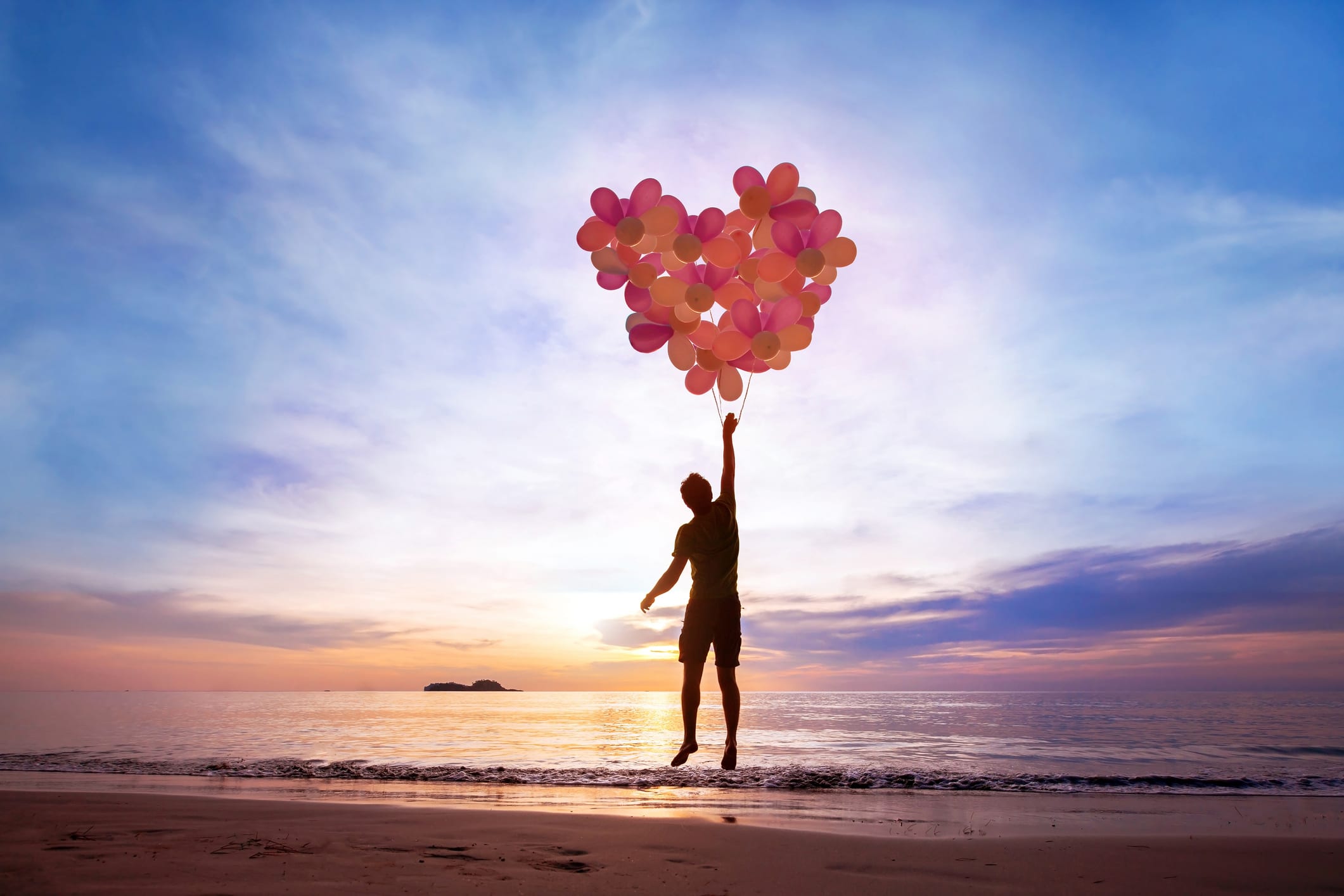 self-care concept, man flying with heart from balloons